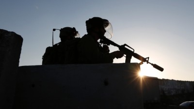 Israeli soldiers keep guard during a Wednesday protest by Palestinians against the Israeli offensive in Gaza, at Qalandia checkpoint near the West Bank city of Ramallah. The threat of renewed war in Gaza loomed on Wednesday as the clock ticked toward the end of a three-day ceasefire with no sign of a breakthrough in indirect talks in Cairo between Israel and the Palestinians. (Mohamad Torokman/Reuters)