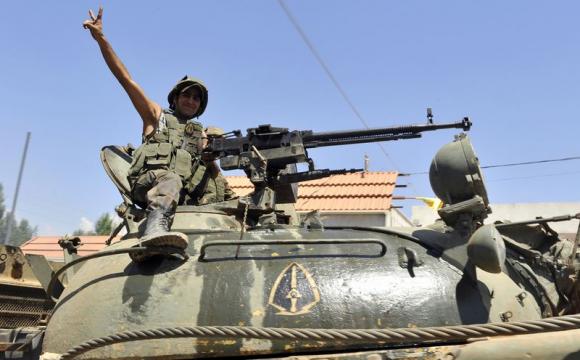 A Lebanese army soldier flashes a victory sign while riding on a tank as they advance towards the Sunni Muslim border town of Arsal, in eastern Bekaa Valley as part of reinforcements August 6, 2014. CREDIT: REUTERS/HASSAN ABDALLAH