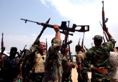 Shiite Muslim fighters from the Saraya al-Salam, a group formed by Iraqi Shiite Muslim cleric Moqtada al-Sadr and tasked with defending the holy sites of Shiite Islam, brandish their weapons as they hold a position on the Jurf al-Sakhr front line, the scene of heavy fighting against advancing Jihadist militants and fighters of the Islamic State, south of the capital Baghdad, on Aug. 18, 2014. Photorgapher: Ali Al-Saadi/AFP via Getty Images