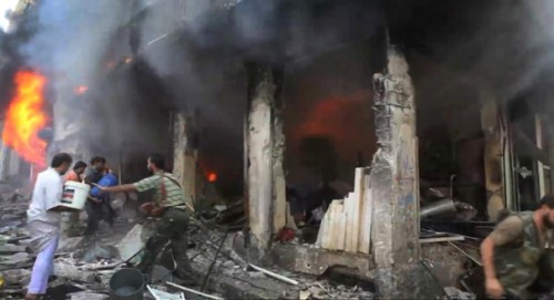 This image taken from video filmed by an independent cameraman and made available on Tuesday, Sept. 4, 2012 shows Syrian men throwing buckets of water toward a burning building in Myasar neighborhood, Aleppo, Syria. Government jets bombed the residential area of Myasar, reducing many of its buildings to rubble and causing a huge fire. (AP Photo/APTN)