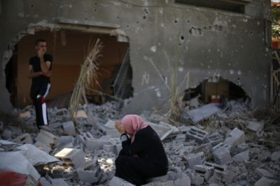 A Palestinian woman reacts upon seeing her destroyed house in Beit Hanoun town, which witnesses said was heavily hit by Israeli shelling and air strikes during an Israeli offensive, in the northern Gaza Strip August 1, 2014.  REUTERS/Suhaib Salem