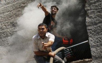 Palestinians react as they put out a fire in an apartment which witnesses said was hit by an Israeli air strike in Beit Lahiya in the northern Gaza Strip August 10, 2014. CREDIT: REUTERS/MOHAMMED SALEM