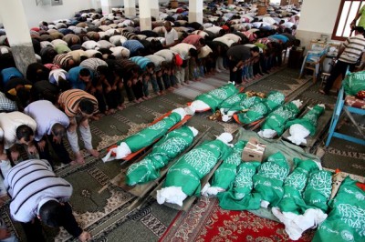 Palestinian mourners pray in a mosque during the funeral for those killed in a three-storey house belonging to the Abu Jamaa family the day before following heavy Israeli bombardment, in Khan Yunis, in the southern Gaza Strip, on July 21, 2014. According to figures released by emergency services' spokesman Ashraf al-Qudra, some 15 people were killed in several strikes across Gaza earlier on July 21, and 45 bodies were pulled from the rubble in areas hit by heavy fighting a day earlier, 23 of them from the house belonging to the Abu Jamaa family in the southern city of Khan Yunis.. Photo by Ezz al-Zanoun