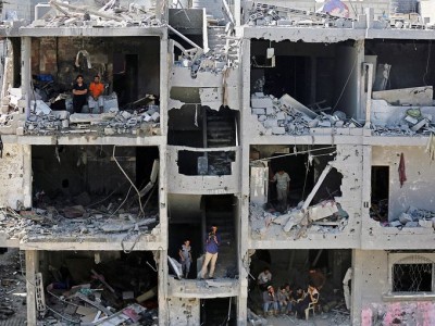 Palestinians sit on rubble of houses destroyed after Israeli airstrikes in Rafah, southern Gaza Strip.  August 17, 2014 (Photo: Mohammed Saber, European Pressphoto Agency)