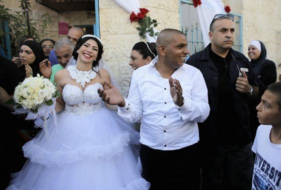 Groom Mahmoud Mansour, 26, and his bride Maral Malka, 23, celebrate with friends and family before their wedding in Mahmoud's family house in Jaffa, south of Tel Aviv August 17, 2014. Israeli police blocked more than 200 far-right Israeli protesters from rushing guests at the wedding of a Jewish woman and Muslim man as they shouted "death to the Arabs" in a sign of tensions stoked by the Gaza war. REUTERS/Ammar Awad
