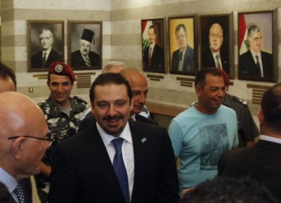 Lebanon's Prime Minister Tammam Salam (L) walks with former prime minister Saad al-Hariri (C) at the government's headquarters in Beirut August 8, 2014. 