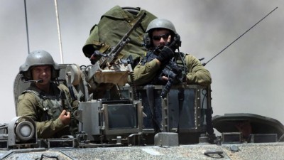 sraeli reserve soldiers are seen on the top of an armored personnel carrier returning to Israel from Gaza Strip, southern Israel, Monday, Aug. 4, 2014.