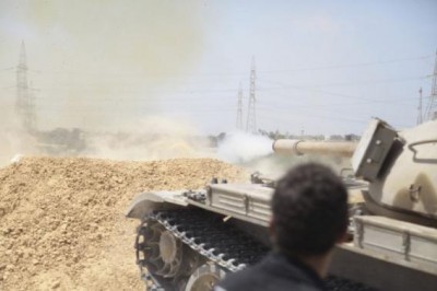 A tank belonging to the Western Shield, a branch of the Libya Shield forces, fires during a clash with rival militias around the former Libyan army camp, Camp 27, in the 27 district, west of Tripoli, August 22, 2014. REUTERS/Stringer