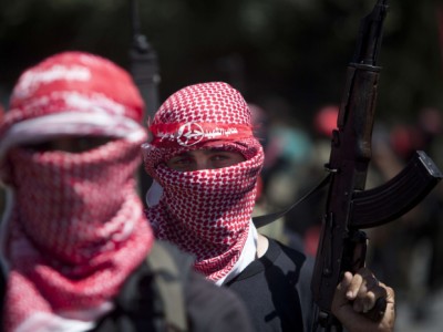 A masked Palestinian militant of the Popular Front for the Liberation of Palestine (PFLP), holds-up his rifle on September 2, 2014  in Gaza city during a rally to celebrate a week after the Egypt-mediated ceasefire between Israel and Hamas. Israel announced on September 1, 2014 it will expropriate 400 hectares (988 acres) of Palestinian land in the occupied West Bank, angering the Palestinians and alarming Israeli peace campaigners. AFP PHOTO/MAHMUD HAMSMAHMUD HAMS/AFP/Getty Images