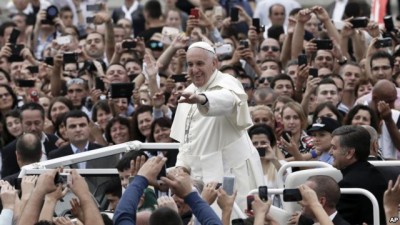 Pope Francis waves to faithful as he is driven through the crowd, in Mother Teresa Square, in Tirana, Sunday, Sept. 21, 2014.