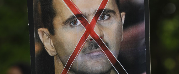 A protester holds up a poster of Syrian President Bashar al-Assad with cross mark over it during a protest rally against Assad's regime outside the Syrian embassy in Kuala Lumpur, Malaysia, Friday, June 8, 2012. (AP Photo/Vincent Thian)