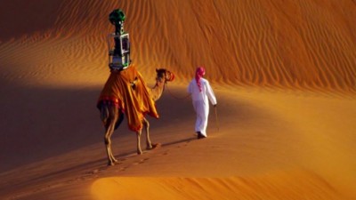A man guides a camel bearing a 360-degree Google Street View camera through the Liwa desert in the United Arab Emirates in the video, "Explore Liwa with Google Maps" video posted to YouTube on Oct. 5, 2014.