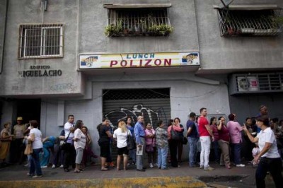 In this Oct. 23, 2014 file photo, people wait in line to enter a small market to try to buy hard to find items like disposable diapers, laundry detergent and razors in downtown Caracas, Venezuela.  (AP Photo/Ariana Cubillos, File) 