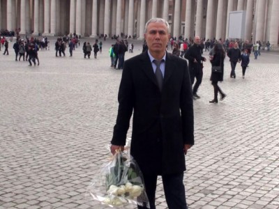 This handout photo grabed from a video made and released by ADNKRONOS on December 27, 2014 shows Mehmet Ali Agca, the Turkish former extremist who attempted to assassinate Pope John Paul II in 1981, holding a wreath of flowers on St. Peter's square in The Vatican. Ali Agca on December 27 laid flowers on the Pope John Paul II's tomb.  