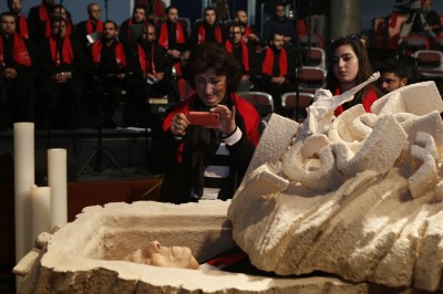 A mourner takes a picture as she pays her respects Monday at the coffin bearing the body of Lebanese poet Said Akl at Notre Dame University in northeast of Beirut.