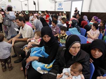 Syrian refugees gather in a room as they wait to be registered at a UNHCR (United Nations Refugee Agency) registration center, one of many across Lebanon, in the northern port city of Tripoli on May 29, 2014. The Lebanese have borne direct and indirect costs of nearly $20 billion as a result of the Syrian refugee crisis, in a country with an annual GDP of $48 billion