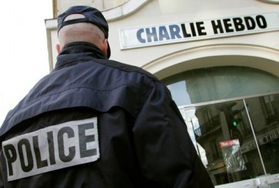 A policeman stands guard outside the French satirical weekly "Charlie Hebdo" in Paris in this February 9, 2006 file photo. REUTERS/Regis Duvignau/Files