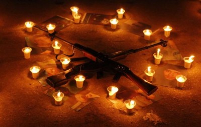 Pictures of war victims are displayed with weapons and candles during a new year event in Salah al-Din neighbourhood in central Aleppo December 31, 2014. REUTERS/Hosam Katan