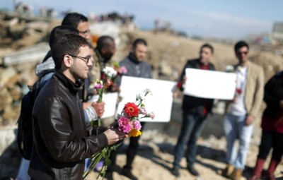 Palestinians carrying flowers gather at the sea of Gaza City, on February 14, 2015, in remembrance of the three victims of the Chapel Hill shooting in the US (AFP Photo/Mahmud Hams)