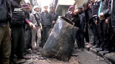Barrel bomb photo provided by Aleppo Media Center (AMC),  which has been authenticated based on its contents and other AP reporting, shows Syrian citizens inspecting an unexploded barrel bomb filled with explosives, which was dropped from a Syrian forces helicopter on a street in Aleppo, Syria. 