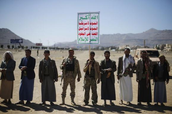 Followers of the Houthi movement attend a gathering to show support to the movement outside the Presidential Palace in Sanaa February 4, 2015. The banner reads: ''Allah is the greatest. Death to America. Death to Israel. A curse on the Jews. Victory to Islam''.