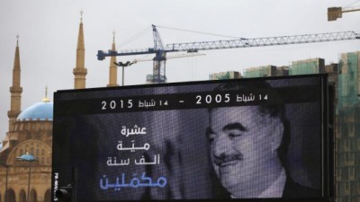 A portrait of slain former Lebanese Prime Minister Rafik Hariri is seen on a digital billboard with Arabic words that read: "Ten, hundred, one thousand years, we continue," in preparation to mark the 10th anniversary of his assassination, near his grave in downtown Beirut, Lebanon, Wednesday, Feb. 11, 2015