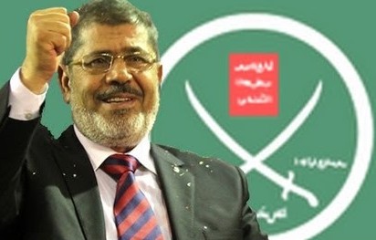 Ousted Egyptian President Mohammed Morsi with banner of the Muslim Brotherhood behind him. The Muslim Brotherhood admitted of making a mistake , apologized  to the Egyptian People 