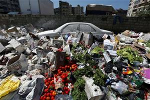 A car is seen between a pile of garbage covered with white pesticide in the Palestinian refugee camp of Sabra in Beirut, Lebanon, Thursday, July 23, 2015. The Lebanese cabinet has failed to agree on a...   (Associated Press)