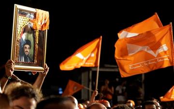 Supporters of Christian leader Michel Aoun hold Free Patriotic Movement flags and a picture of Hezbollah chief Hassan Nasrallah, 