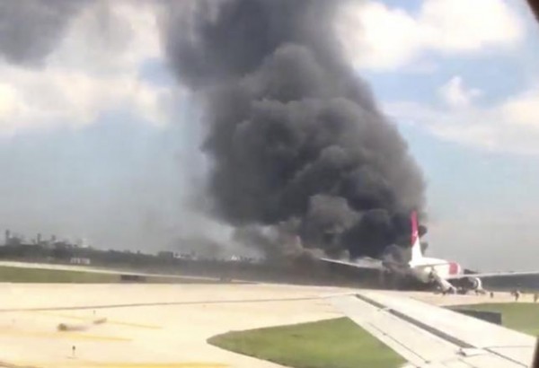 A still image from a handout video footage by Mike Dupuy, a passenger in another airplane, shows Dynamic International Airways' Boeing 767's engine on fire in Fort Lauderdale, Florida, October 29, 2015.  REUTERS/Mike Dupuy