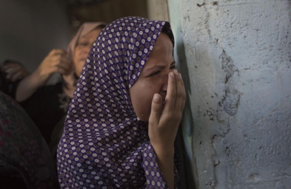 Palestinian mourners weep during the funeral of two-year-old, Rahaf Hassan, and her 30-year-old pregnant mother, Noor Hassan, who were killed in Israeli air strike Sunday morning, during their funeral in the family house south of Gaza city in the Gaza Strip, Sunday, Oct. 11, 2015. In response to renewed rocket fire toward Israel, the military said it carried out airstrikes in Gaza targeting Hamas weapons manufacturing facilities. Ashraf Al-Kidra, a Health Ministry spokesman in Gaza, said a nearby home was struck, which killed Rahaf and Noor and wounded four others including Noor's husband and son. (AP Photo/ Khalil Hamra)