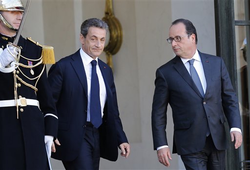 Former French President, Nicolas Sarkozy, leaves the Elysee Palace after a meeting with France's President, Francois Hollande, right,  in Paris, Sunday, Nov. 15, 2015. French President Francois Hollande vowed to attack the Islamic State group without mercy as the jihadist group admitted responsibility Saturday for orchestrating the deadliest attacks inflicted on France since World War II. (AP Photo/Jacques Brinon)