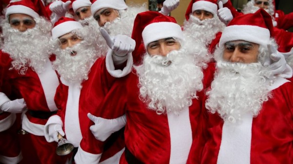 Lebanese men and women wearing Santa Claus costumes enjoy a parade during a Christmas event, in downtown Beirut, Lebanon, Saturday, Dec. 19, 2015.AP