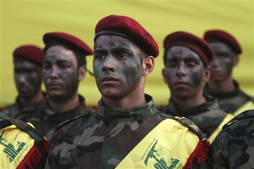  In this Monday Oct. 12, 2015 file photo, Hezbollah fighters stand by the coffin of senior Hezbollah commander Hassan Hussein al-Haj during his funeral procession in the southern Lebanese village of Loueizeh, Lebanon. At tightly guarded facilities in south Lebanon, men as young as 17 undergo intensive training on how to use automatic rifles and heavy machine guns before being shipped off to Syria to fight alongside President Bashar Assad's forces. The training is part of a massive Hezbollah recruitment effort to make up for its human losses in Syria's war, now approaching the death toll incurred by the group during 18 years of fighting Israeli occupation.(AP Photo/Mohammed Zaatari, File)