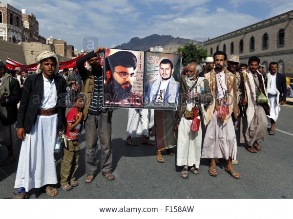 Houthi rebels hold a poster of Hezbollah chief Hassan Nasrallah  and Houthi chief Abdulmalik al-Houthi