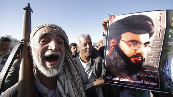 A Houthi militant shouts slogans as he stands next a poster of Lebanon's Hezbollah leader Sayyed Hassan Nasrallah during a rally against U.S. support to Saudi-led air strikes, in Yemen's capital Sanaa, February 19, 2016. REUTERS/Mohamed al-Sayaghi