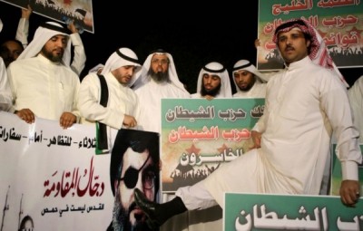 Kuwaiti protesters hold placards against Lebanese Shiite movement Hezbollah's chief Hassan Nasrallah (portrait) during a protest in front the Lebanese embassy against Hezbollah's and Iran's involvement in Syria, in Kuwait city on June 11,2013. Photo: AFP PHOTO/YASSER AL-ZAYYAT