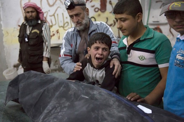 A Syrian boy is comforted as he cries next to the body of a relative who died in a reported airstrike on April 27, 2016, in the rebel-held neighborhood of al-Soukour in the northern city of Aleppo. A series of airstrikes and shelling by the Syrian government has left more than 60 people dead in less than 24 hours in the city of Aleppo in Syria on April 28 (Karam Al-Masri/AFP/Getty Images) 