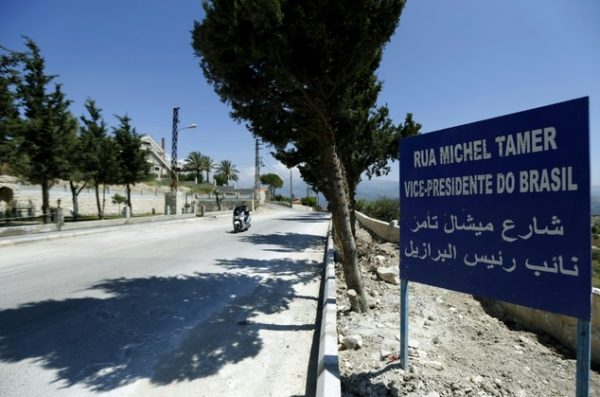A man rides past a sign reading in Portuguese and Arabic: "Michel Temer Street, Vice President of Brasil" in the village of Btaaboura, north of Beirut, where Temer's Lebanese father grew up, on May 12, 2016 ©Joseph Eid (AFP)