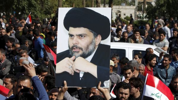 A demonstrator holds a picture of Moqtada al-Sadr during a demonstration in Baghdad 