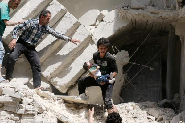 Syrians evacuate a toddler from a destroyed building following a reported air strike on the rebel