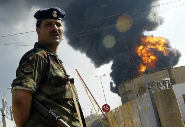 A Lebanese soldier stands guard in front flaming fuel tanks at the Beirut International airport, after an Israeli air strike on July 14, 2006 ©Ramzi Haidar (AFP/File)
