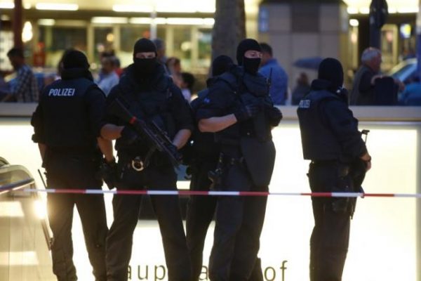 Special force police officers stand guard at an entrance of the main train station, following a shooting rampage at the Olympia shopping mall in Munich. REUTERS/Michael Dalder