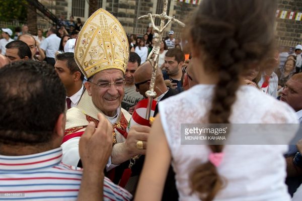 Lebanese Maronite Patriarch Beshara Rai (C) blesses exiled members of Israels former South Lebanon Army (SLA) proxy militia and their families on May 28, 2014, outside Saint Peter's church in the Israeli village of Capernaum   