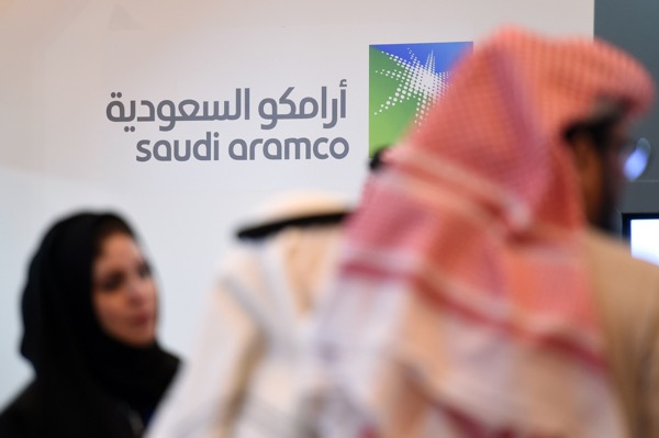 Saudi and Foreign investors stand in front of the logo of Saudi state oil giant Aramco during the 10th Global Competitiveness Forum on January 25, 2016, in the capital Riyadh. The an annual event brings together high-ranking Saudi officials and world business leaders. / AFP / Fayez Nureldine        (Photo credit should read FAYEZ NURELDINE/AFP/Getty Images)