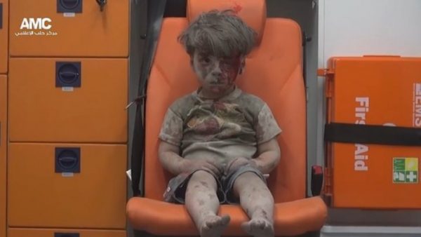  Screen grab from a video released by the Syrian opposition Aeppo Media Centre showing a young boy sitting in an ambulance, covered head to toe with dust, after being pulled from rubbles