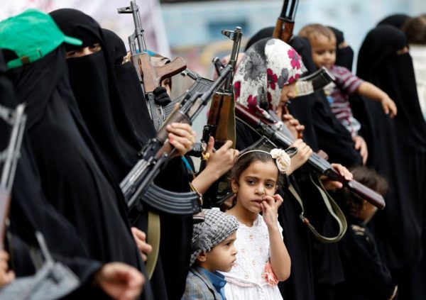 A girl looks at armed women loyal to the Houthi movement as they take part in a parade to show support for the movement in Sanaa. REUTERS/Khaled Abdullah