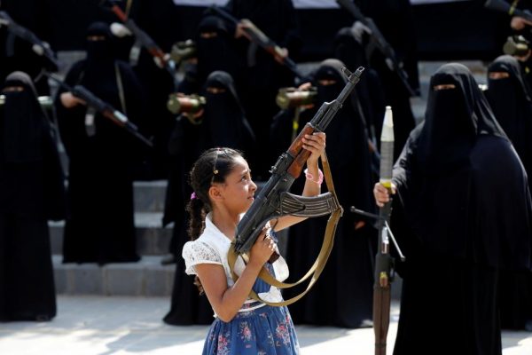 A girl holds a rifle in front of women loyal to the Houthi movement taking part in a parade to show support to the movement in Sanaa, Yemen September 6, 2016. REUTERS/Khaled Abdullah
