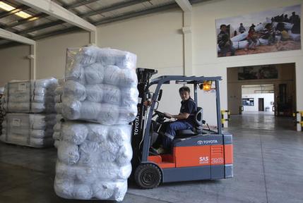 A lift truck driver uploads family tents for the Mosul refugees at the UNHCR warehouses, part of the International Humanitarian City (IHC) in Dubai, United Arab Emirates, Thursday, Oct. 27, 2016. The United Nations' refugee agency is shipping tents, blankets and other aid from the United Arab Emirates to northern Iraq to help those affected by the U.S.-led push to retake Mosul from the Islamic State group. (AP Photo/Kamran Jebreili)