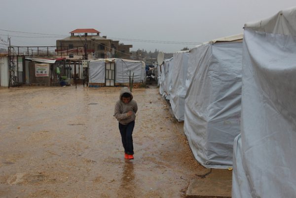 A Syria refugee child runs for cover from torrential rain at al-Reyhaniyeh (MEE/Tom Rollins) Tom Rollins's picture 
